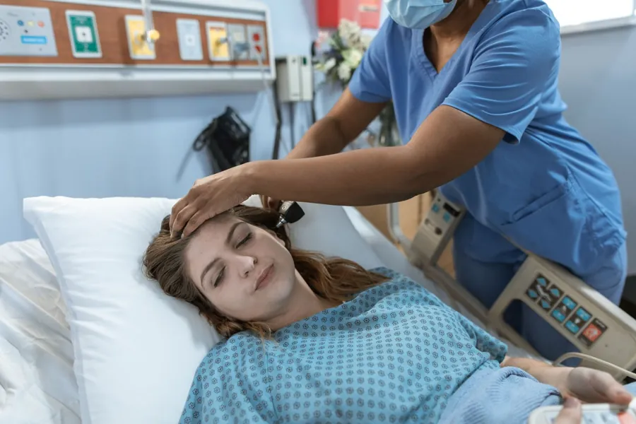 Profissional de saúde conversando com uma pessoa sentada em sala de atendimento clara