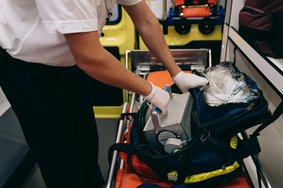 Socorrista abrindo uma mochila de emergência com materiais organizados