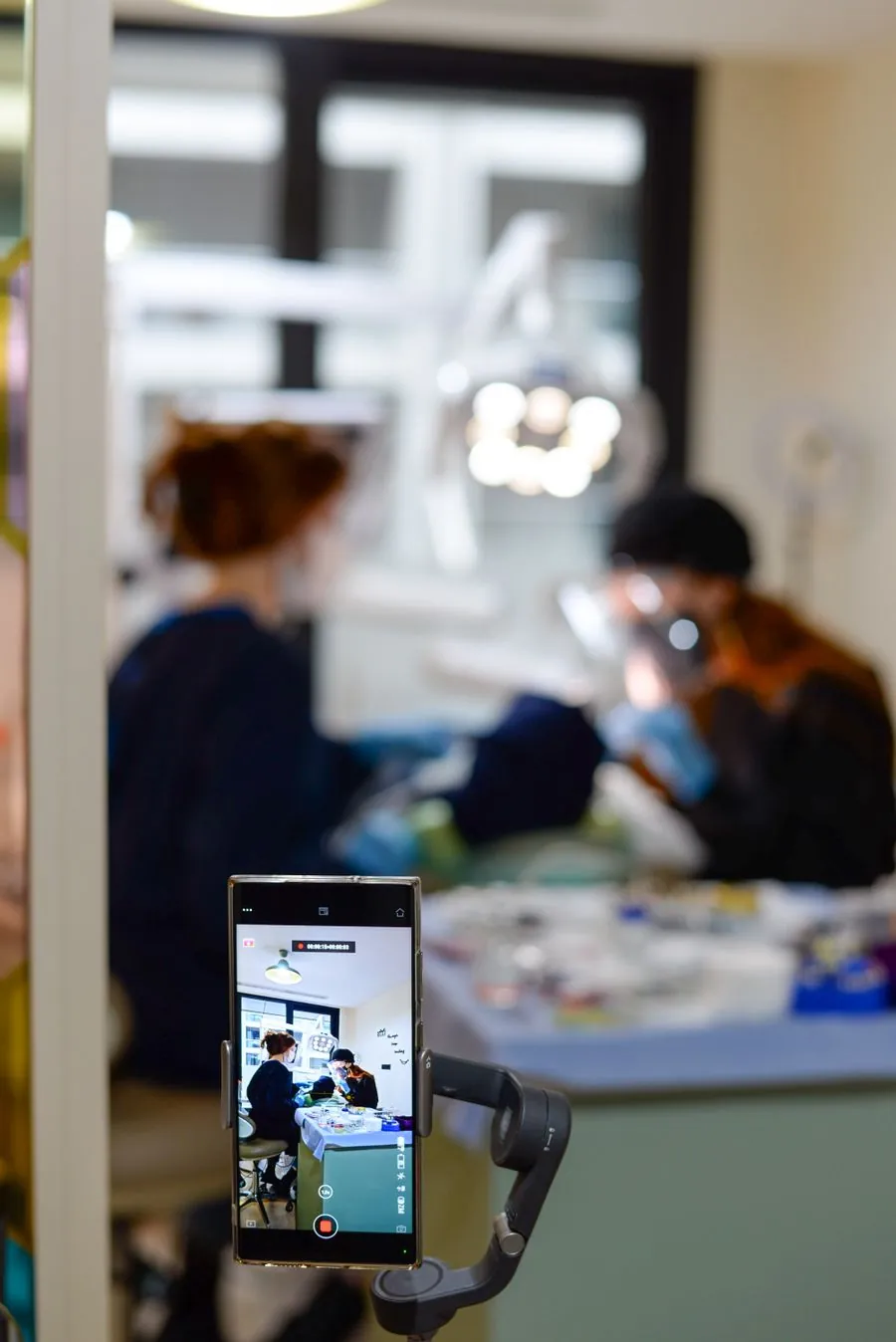Consultório odontológico vazio com cadeira, refletor e instrumentos dispostos